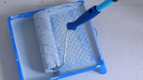 Dipping paint roller in painting pan with grey paint to color wall closeup view. Stock-Footage 136219063