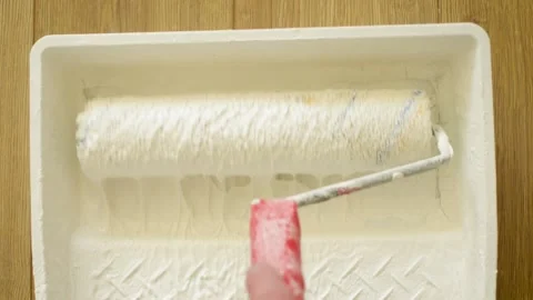 Dipping the paint roller into the white paint. Clip. Rolling paint. 動画素材 140053250