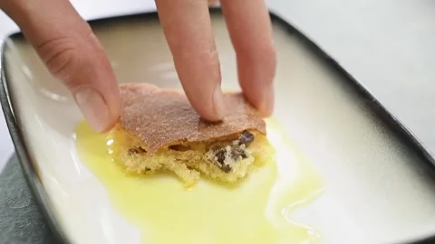 Dipping a piece of bread into a bowl with olive oil. Video stock 161017045
