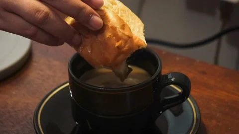 Dipping a piece of bread into a cup of coffee 動画素材 341842595