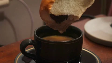 Dipping a piece of bread into a cup of coffee Stock Footage 341842601