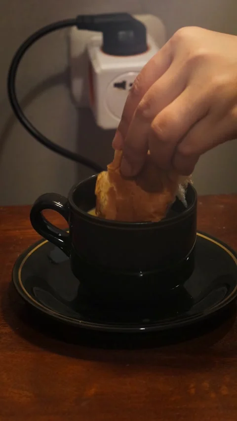 Dipping a piece of bread into a cup of coffee Stock Footage 341842602