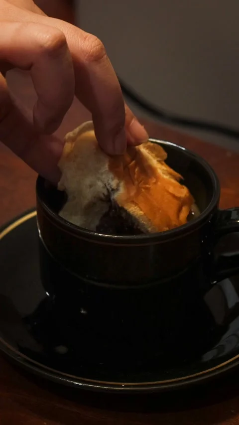 Dipping a piece of bread into a cup of coffee Stock Footage 341842611