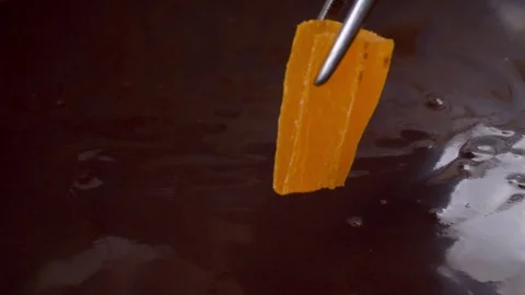 Dipping a piece of candied fruit in liquid chocolate Stock Footage 123302964