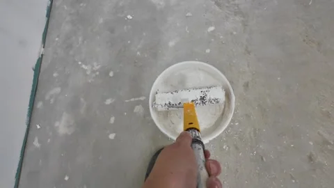 Dipping the putty roller into a bucket of putty Stock Footage 313823388