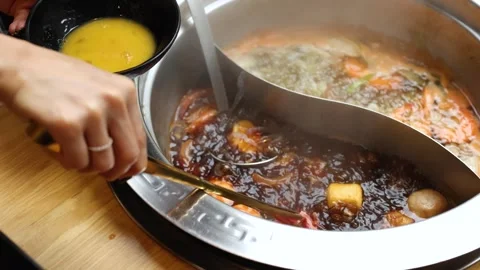 Dipping Raw Beef in Egg Before Cooking in Dual Broth Hotpot Vídeos de archivo 321384489