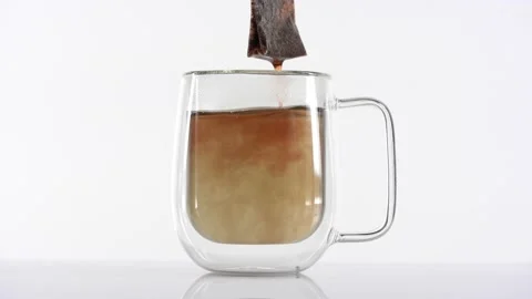 Dipping red tea bag in a transparent mug with hot water on white background Stock Footage 144431582