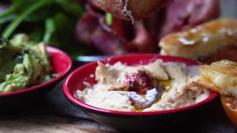 Dipping rustic bread into hummus Stock Footage 128260837