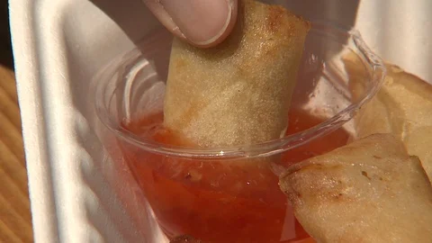 Dipping Spring Roll in Sweet and Sour Sauce Stock Footage 107744857