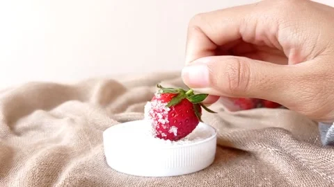 Dipping a strawberry into a small jar of sugar Stock Footage 145673473