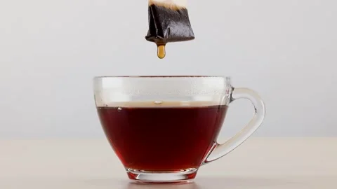 Dipping Tea Bag into Glass Cup of Hot Black Tea Stock Footage 345099806