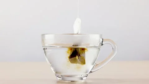 Dipping Tea Bag in Glass Cup with Hot Water Brewing Herbal Tea Stock Footage 346271095
