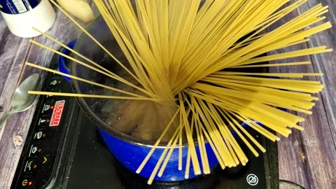 Dips spaghetti into boiling water Stock Footage 227723007