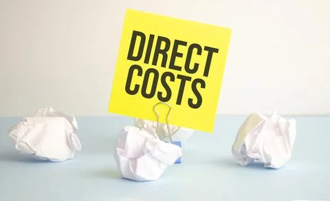 DIRECT COSTS text written on notepad on the blue background Stock Photos