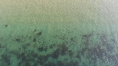Direct overhead shot flying towards sandy beach Video stock 124702294