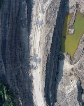 Direct top-down aerial view of a mining pit featuring a central haul road, .. Stock Photos