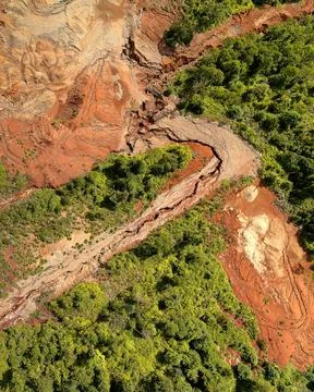 Direct top-down aerial view of a winding earth trench and water channel cut.. Stock Photos