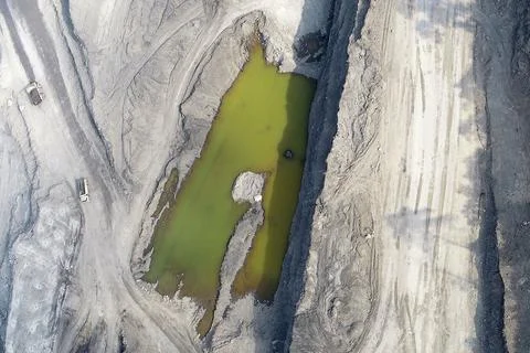 Direct top-down vertical aerial view of an open-pit mining site featuring a.. Stock Photos