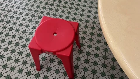 Direct top-down view of a red plastic stool and table set on vintage mosaic Stock Footage 339019746