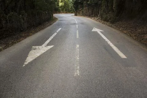 Direction arrows on empty asphalt road Stock Photos