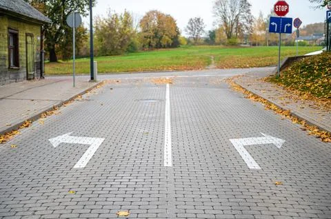 Direction arrows on paved road at intersection, choice concept Stock Photos