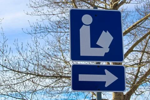 Direction to Library Sign with Tree in Background Stock Photos
