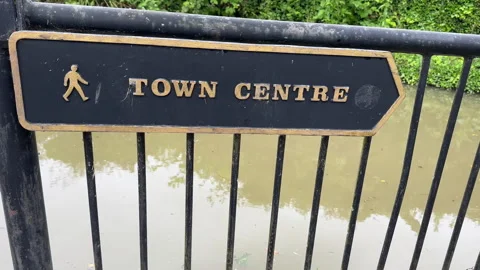 Direction sign to Town Centre on railing above water. Vídeos de archivo 306576651