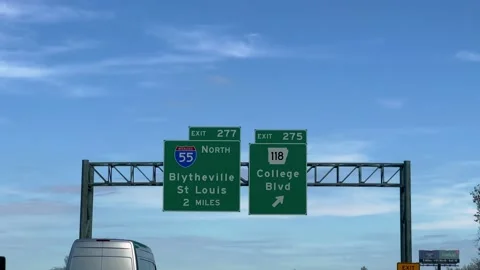 Direction signs on the highway to I-55 Blytheville and St Louis - POV driving by Stock Footage 221883399