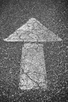 Directional arrow on asphalt Stock Photos