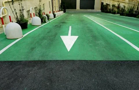 Directional arrow on green path in Rome, Green urban driveway in Rome Foto stock