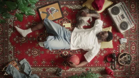 Directly Above of Black Man Relaxing on Rug with Basketball and Cute Cat Stock Footage 339845950