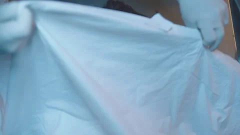 Directly above a female corpse on the table and mortician doing his job Stock Footage 283144302