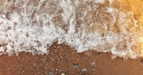 Directly Above full frame Close Up View Wave Surf Crashing into Beach Shore with Stock Photos