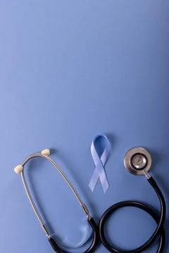 Directly above shot of blue stomach cancer awareness ribbon and stethoscope over Stock Photos