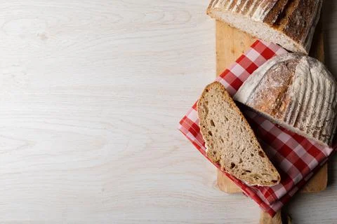 Directly above shot of bread with checked pattern napkin on serving board at Stock Photos