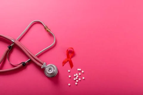Directly above shot of red aids awareness ribbon with stethoscope and medicines Stock Photos