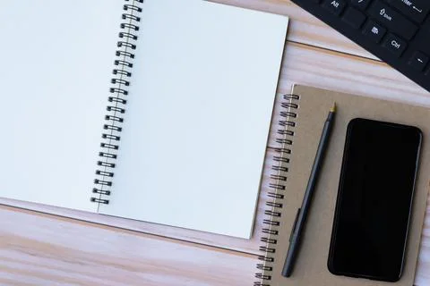 Directly above view of notepad, pen, smartphone and keyboard on wooden desk. Stock Photos