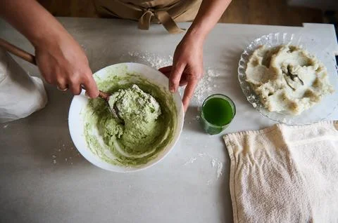 Directly above woman's hands using a wooden spoon mixing ingredients and knea Stock Photos