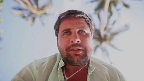 Directly below shot of concerned man, who asking something. Desert island. Stock Footage 80423448