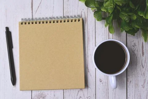 Directly view of notepad and pen with cup of coffee on wooden desk Stock Photos