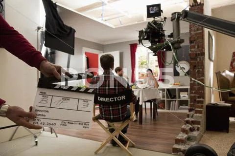 A director on a film set watching actors perform a scene Stock Photos