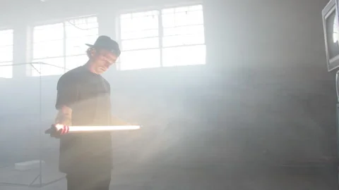 Director Holds Lighting Near Stack Of TV's Stock Footage 270326055