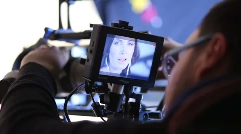 Director looking on camcorder display during shooting singer Video stock 42752792