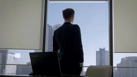 Director In Office At The Workplace Standing At Window And Looks At His Watch Stock Footage 106143521