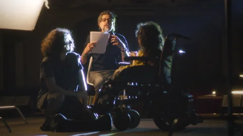 Director talking to actor and disabled actress Stock Footage 201427659