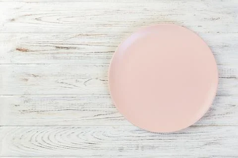 Directy above Empty pink matte plate on white wooden background with copy spa Stock Photos