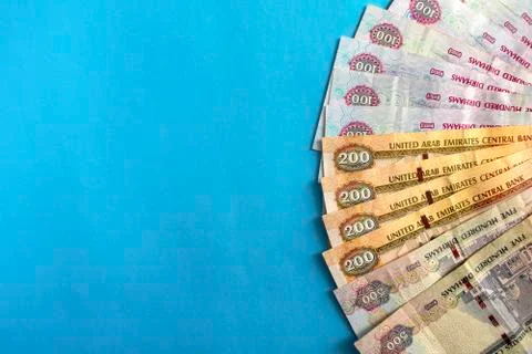 Dirham banknotes on blue background with copy space Stock Photos