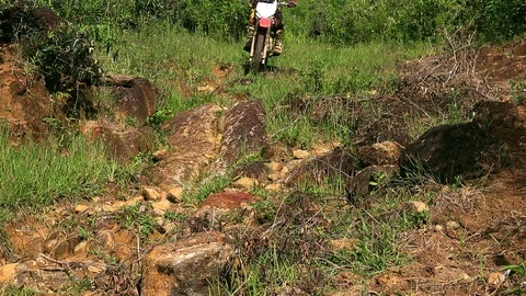 Dirt bike going down a big rock Stock Footage 86694047