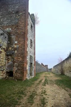 Dirt path bordered by fortifications in a park on a cloudy day Stock Photos