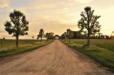 Dirt Path Leading to House Under Clear Day Sky Stock Photos